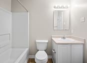 Thumbnail 13 of 20 - A white toilet sits next to a sink in a bathroom.