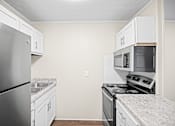 Thumbnail 7 of 20 - A kitchen with a stainless steel refrigerator, microwave, and oven.