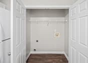 Thumbnail 6 of 22 - A white closet with a wooden floor and white walls.