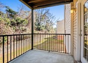 Thumbnail 21 of 22 - A balcony with a black railing and a view of a green lawn and trees.