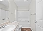 Thumbnail 19 of 22 - A white bathroom with a toilet, sink, and bathtub.