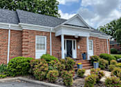 Thumbnail 13 of 14 - a brick building with a black door and white trim