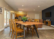 Thumbnail 11 of 21 - A dining room with a wooden table and chairs.