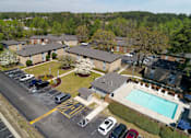 Thumbnail 19 of 20 - A parking lot with a pool and apartment buildings in the background.