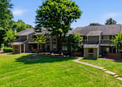 Thumbnail 11 of 29 - A large house with a green lawn in front.