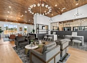 Thumbnail 2 of 19 - A modern living room with a wooden ceiling and a variety of seating options.