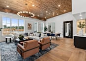 Thumbnail 6 of 19 - A modern living room with a wooden ceiling and a large window.