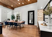 Thumbnail 4 of 19 - A dining room with a wooden table and chairs.