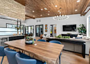 Thumbnail 3 of 19 - A modern dining room with a wooden table and blue chairs.