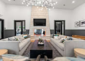 Thumbnail 1 of 19 - A living room with a grey couch and a black coffee table.