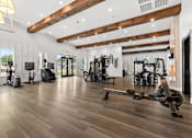 Thumbnail 10 of 19 - A gym with a variety of equipment including treadmills, weights, and exercise machines.