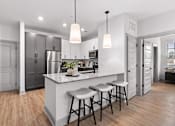 Thumbnail 14 of 19 - A kitchen with a white countertop and bar stools.