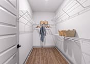 Thumbnail 18 of 19 - A white closet with a coat hanging on a rod.