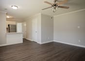 Thumbnail 9 of 10 - A room with a ceiling fan and wooden flooring.