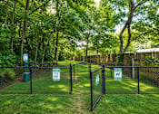 Thumbnail 12 of 21 - A sign on a fence indicates that dogs are allowed in the park.