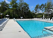 Thumbnail 12 of 25 - 3-Bedroom Garden-Style Apartments In Weaverville, NC - Highline North - Resort-Style Salt Water Pool With Plenty Of Lounge Chairs And Umbrellas Surrounded By Tall Trees