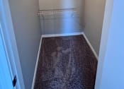Thumbnail 29 of 29 - A small, empty room with a carpeted floor and a few shelves.