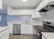 Thumbnail 4 of 29 - A kitchen with white cabinets and a black stove top oven.