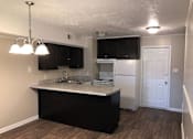 Thumbnail 8 of 13 - A kitchen with black cabinets and a white fridge.