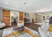 Thumbnail 23 of 46 - A living room with a white couch and a coffee table.