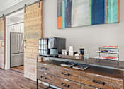 Thumbnail 22 of 46 - A kitchen with a wooden bar counter and a refrigerator.