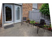 Thumbnail 7 of 13 - A patio with a table and chairs is shown.