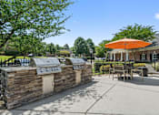Thumbnail 46 of 46 - A picnic area with a stone wall and a grill.