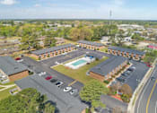 Thumbnail 10 of 13 - A parking lot with a pool in the middle of a building complex.