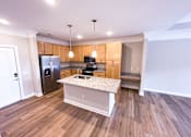 Thumbnail 3 of 21 - A kitchen with a granite countertop and stainless steel appliances.