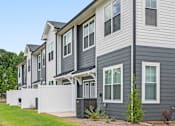 Thumbnail 31 of 31 - A row of houses with grey siding and white trim.