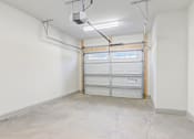 Thumbnail 10 of 25 - A garage with a white wall and a white door.