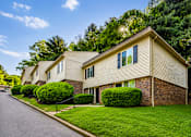 Thumbnail 19 of 21 - A house with a well-maintained lawn and a clear sky above.