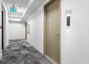 Thumbnail 38 of 59 - a door in a hallway of a building with white walls