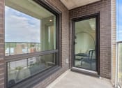 Thumbnail 32 of 59 - a balcony with a large window and a brick wall