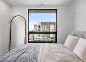 Thumbnail 45 of 59 - a bedroom with a bed and a large window