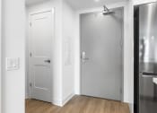 Thumbnail 35 of 59 - an empty room with a white door and a stainless steel refrigerator