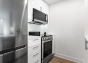 Thumbnail 42 of 59 - a kitchen with a stove and a microwave and a television