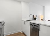 Thumbnail 49 of 59 - a kitchen with white cabinets and a sink and a dishwasher