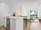 Thumbnail 34 of 59 - an open kitchen with an island and a living room with a table and chairs
