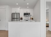 Thumbnail 23 of 59 - a kitchen with a white counter top and a refrigerator