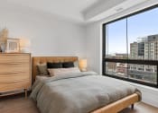 Thumbnail 19 of 59 - a bedroom with a bed and a large window