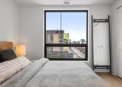 Thumbnail 51 of 59 - a bedroom with a large window and a bed