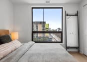 Thumbnail 11 of 59 - a bedroom with a large window and a bed