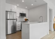 Thumbnail 58 of 59 - a kitchen with white cabinets and a stainless steel refrigerator