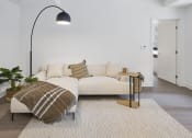 Thumbnail 18 of 46 - a living room with a couch and a lamp