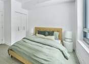 Thumbnail 30 of 46 - a bedroom with white walls and a bed with grey blankets and pillows