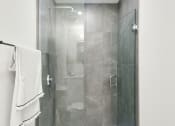 Thumbnail 17 of 46 - a bathroom with a shower and a sink and a towel