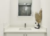Thumbnail 13 of 46 - a white bathroom with a sink and a mirror