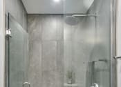 Thumbnail 31 of 46 - a shower with a glass door in a bathroom