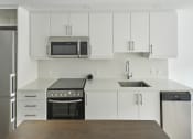 Thumbnail 24 of 46 - a kitchen with white cabinets and stainless steel appliances